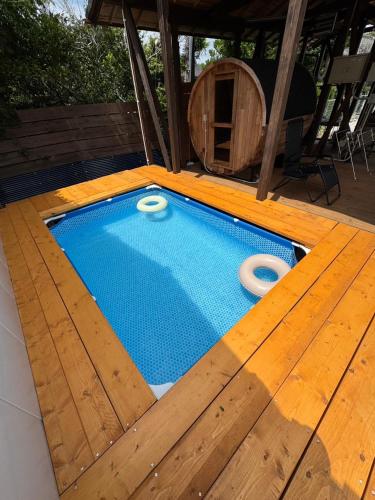 a swimming pool with a wooden floor and a swimming pool at Sunny side story hotel 九十九里 in Kujukuri