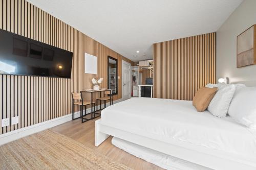 a bedroom with a large white bed and a desk at Cozy Creek Den - Updated Nov 2025 in Whistler