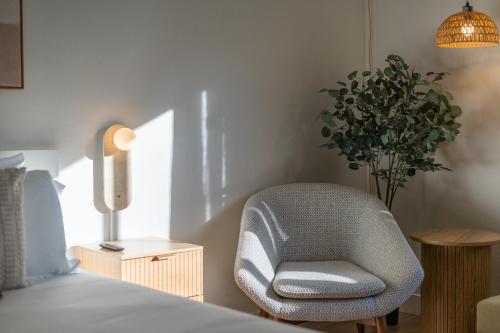 a bedroom with a chair next to a bed at Cozy Creek Den - Updated Nov 2025 in Whistler