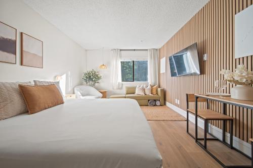 a bedroom with a large bed and a living room at Cozy Creek Den - Updated Nov 2025 in Whistler