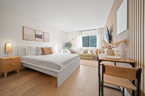 a white bedroom with a bed and a couch at Cozy Creek Den - Updated Nov 2025 in Whistler