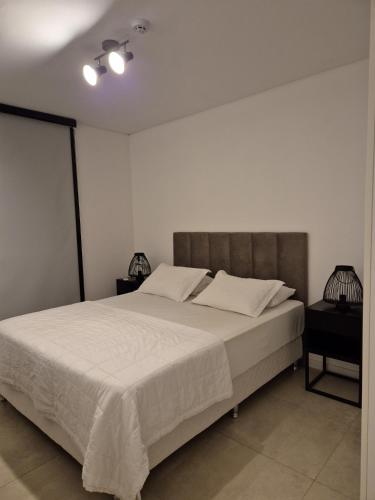 a bedroom with a large bed with white sheets at Feel Premiun 1204 in Asuncion