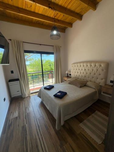 a bedroom with a large bed and a large window at Cabaña La Arianna in Santa Teresita