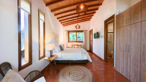 a bedroom with a bed in a room with windows at Casa Eve Club in Estación El Salto