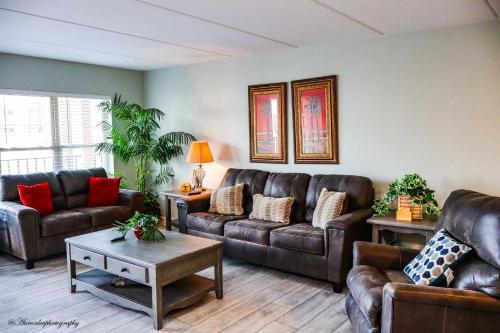 Una sala de estar con sofás de cuero y una mesa. en BEACHVIEW 110 condo, en South Padre Island