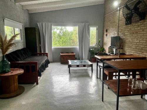 a living room with a couch and a table at Terrazas del Pinar, Loft con pileta exclusiva en bosque serrano in Villa Ciudad de America