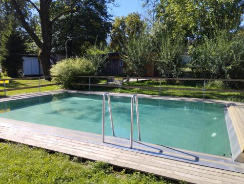 a swimming pool in a yard with grass and trees at Včelín - Camp pod kaštany in Morávka