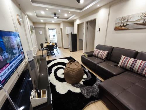 a living room with a couch and a tv at Ayu Blue Lagoon PD by GPH in Gua Sai
