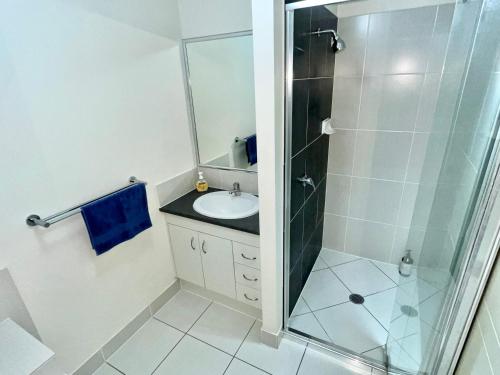 a bathroom with a glass shower and a sink at Private Room with shared bathroom in Browns Plains