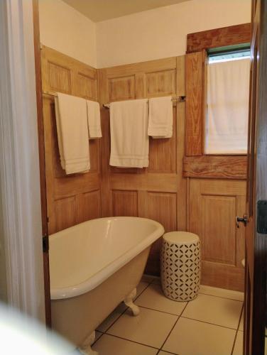 a bathroom with a bath tub and towels at Mid-Century Modern meets Cajun Creole in Baton Rouge