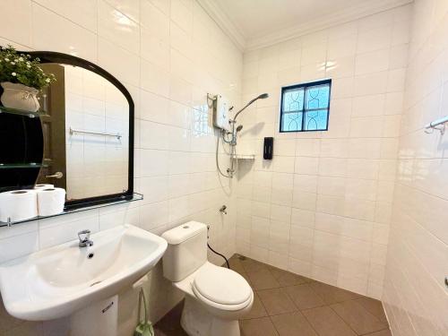 a white bathroom with a toilet and a sink at Deco Home The Oasis Mesilau at Kundasang in Kundasang