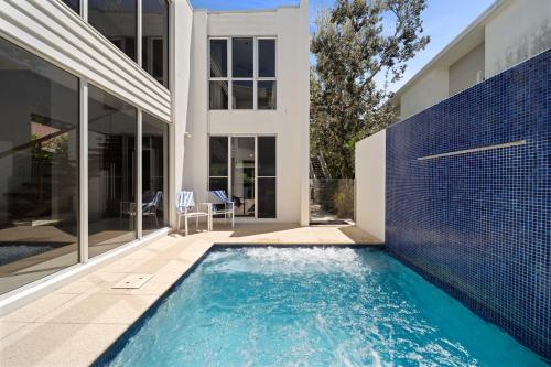 a swimming pool in front of a house at Saltbreeze - Laidback Poolside Living in Twin Waters