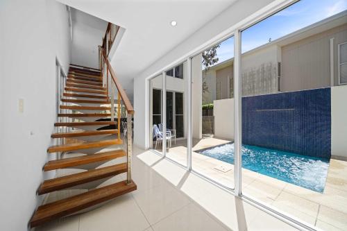 a staircase in a house with a swimming pool at Saltbreeze - Laidback Poolside Living in Twin Waters