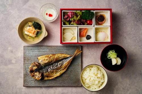 a table with a plate of food and bowls of food at Hotel New Akao in Atami
