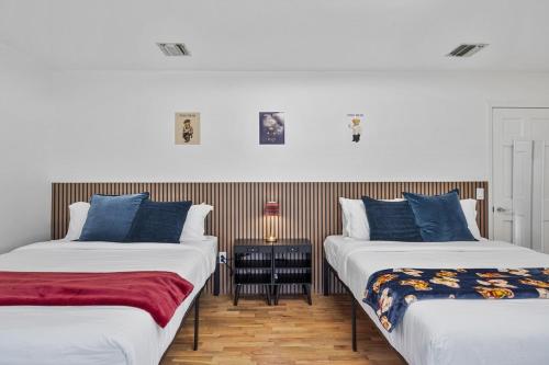 Dos camas una al lado de la otra en una habitación. en Family Staycation Retreat 7BDR Sauna Games, 