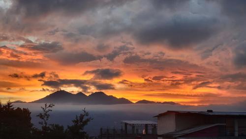Historika Hostel Cultural في سان كريستوبال دي لاس كازاس: غروب الشمس مع الغيوم والجبال في الخلفية