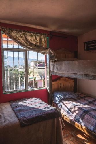 two bunk beds in a room with a window at Historika Hostel Cultural in San Cristóbal de Las Casas