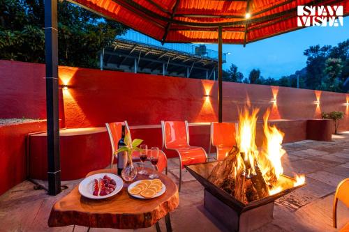 un foyer extérieur avec une table et des plaques de cuisson dans l'établissement StayVista at Hermitage 4BR - Boutique Stay - Relax in Nature, à Irpu
