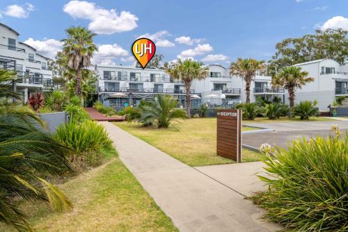 a kite flying over a sidewalk in front of condos at Corrigans Beach Escape Studio in Batehaven