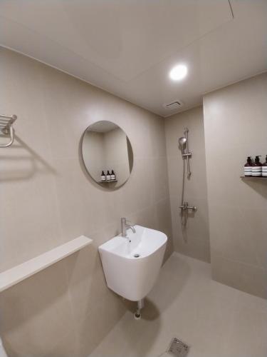a white bathroom with a sink and a mirror at GaGa Hotel dongdaemun in Seoul