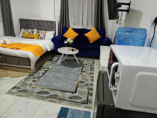 a living room with a bed and a table at Naivera Membley star heights in Ruiru