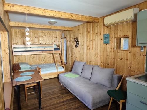 a living room with a couch and a bunk bed at Filipka - Camp pod kaštany in Morávka