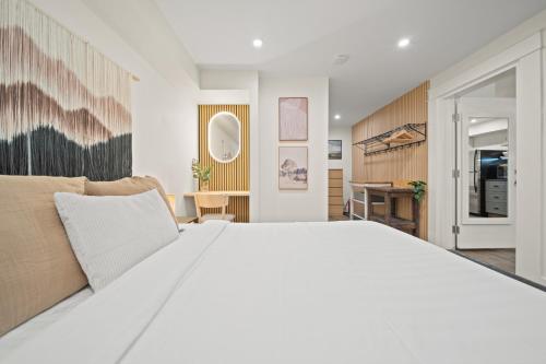 a bedroom with a large white bed and a desk at Whistler Lakeside Hideaway in Whistler