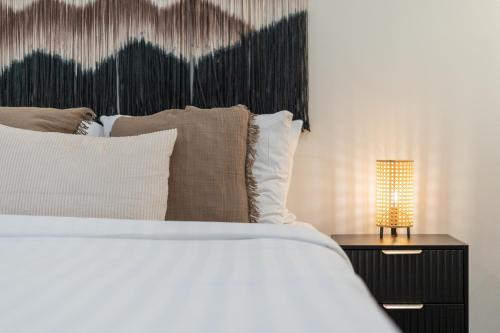 a bed with pillows and a lamp on a table at Whistler Lakeside Hideaway in Whistler