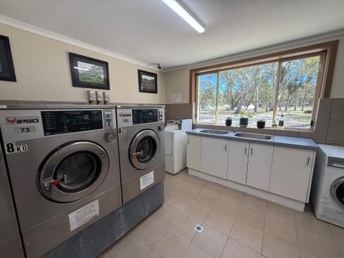 a laundry room with two washing machines and a sink at Coonawarra Bush Holiday Park in Coonawarra