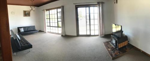 a living room with a tv and a couch at Relaxing Vintage Cottage in Corrimal