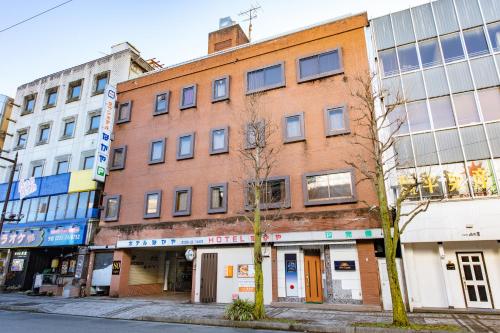 an old brick building on a city street at Town Hotel Nakaya in Iida