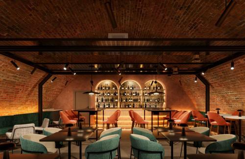 a restaurant with tables and chairs and a brick wall at Hampton By Hilton Manchester City Centre in Manchester