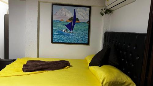 a yellow bed with a towel on top of it at Posada Ashanty in Providencia
