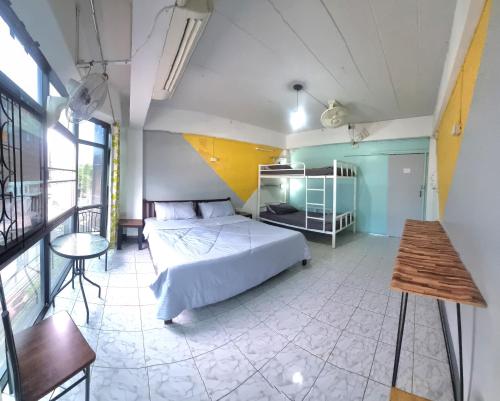 a bedroom with a bed and a table in a room at U2 Hostel in Chiang Mai