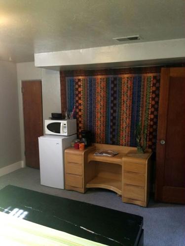 a small kitchen with a refrigerator and a microwave at King Suite Between City and Slopes in Denver