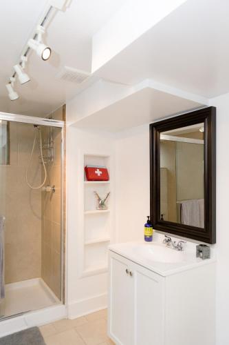 a bathroom with a sink and a shower with a mirror at King Suite Between City and Slopes in Denver