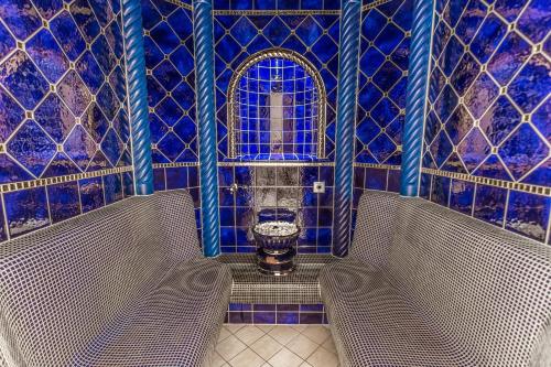 a bathroom with two benches in a room with blue tiles at Hotel Plattenhof in Lech am Arlberg