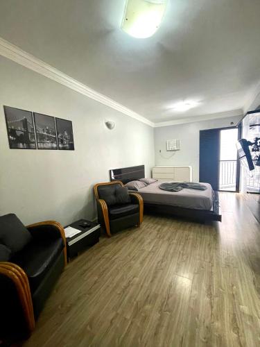 a bedroom with a bed and two chairs in it at Flat Palladium Rooftop Pool in São Vicente