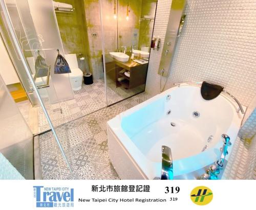 a large bathroom with a tub and a sink at Thinker Hotel in Yingge