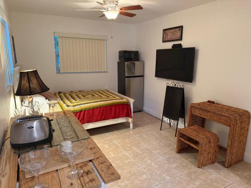 a room with a bed and a table with a television at El Shaddai Faithfully Beach in Hollywood