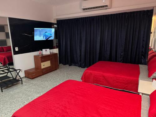 a hotel room with two beds and a flat screen tv at Suite VIP frente al mar en el corazón de Acapulco in Acapulco