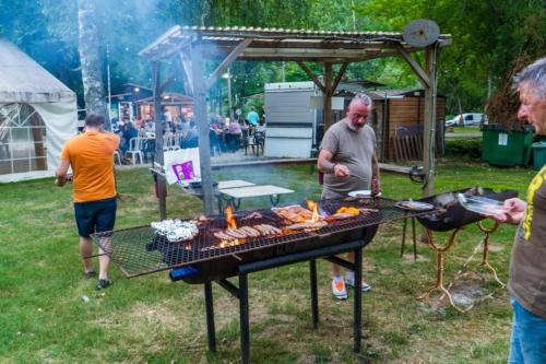 eine Gruppe von Menschen, die um einen Grill stehen in der Unterkunft Camping 3 étoiles - Piscine - eeicbi in Le Change