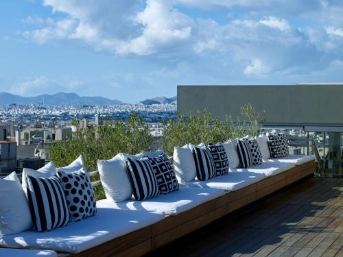 a row of pillows sitting on a bench on a roof at Fresh Hotel, a member of Design Hotels in Athens