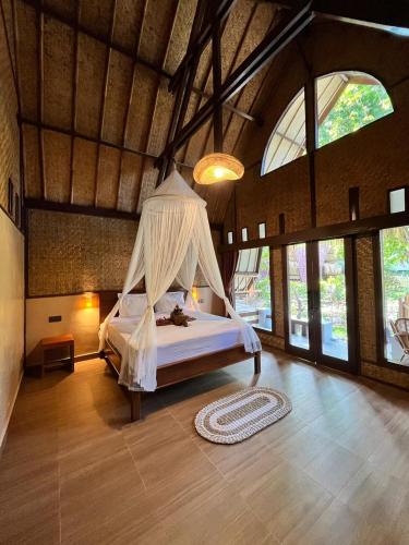 a bedroom with a bed with a mosquito net at Gila House - Adults only in Gili Islands