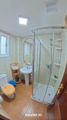 ein Badezimmer mit Dusche, Toilette und Waschbecken in der Unterkunft El bosque NOMADA 1 in El Bosque