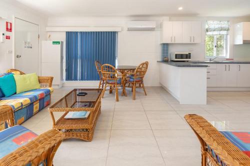 a living room with a couch and a table and chairs at Blueys Beach Villa Manyana 14 in Blueys Beach