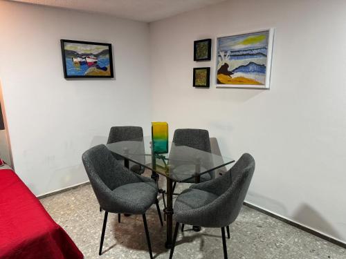 a room with a glass table and chairs at Suite VIP frente al mar en el corazón de Acapulco in Acapulco