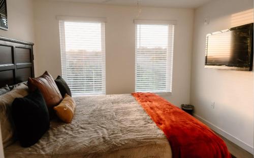 a bedroom with a large bed and two windows at Luxury Mountain Views at Prime Location Huntsville in Huntsville
