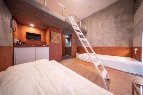 a room with two beds and a ladder at Plusone Fujisaki in Fukuoka