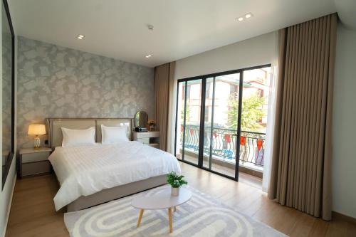 ein Schlafzimmer mit einem Bett und einem großen Fenster in der Unterkunft T-Moon Homestay in Binh Hai